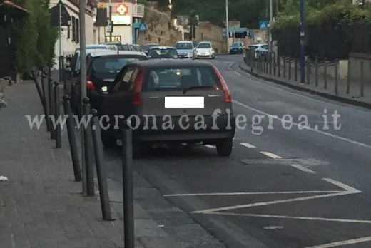 Un'auto ferma sulla fermata dei bus