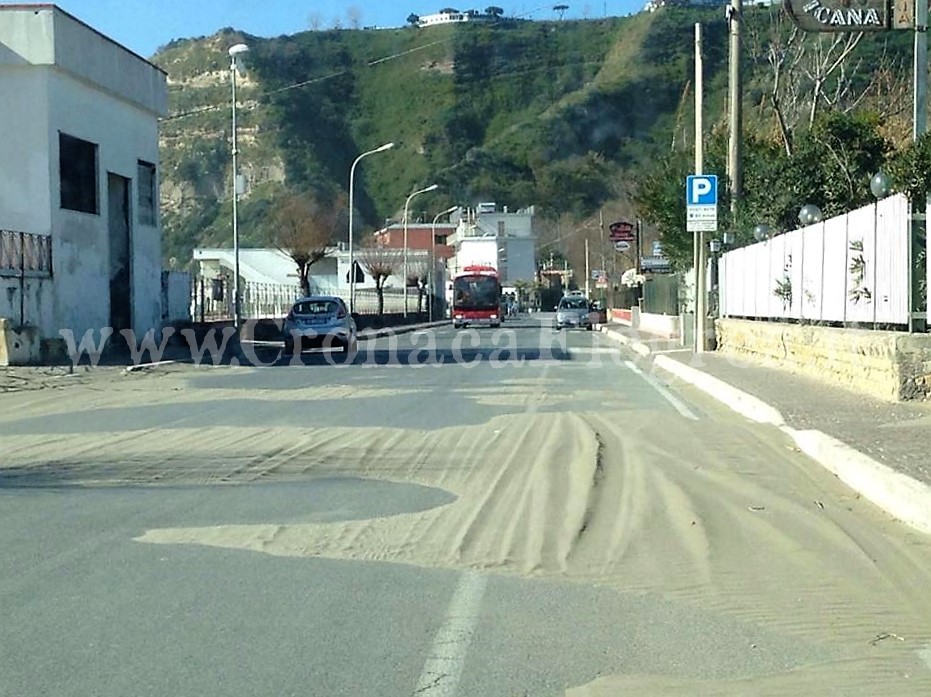 BACOLI/ Vento forte, la sabbia finisce in strada: pericoli per auto e moto