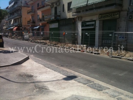 Le facciate delle attività commerciali coperti da reti metalliche del cantiere di lavoro in via Campi Flegrei, ad Arcofelice