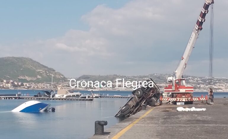 Paura a Bacoli: camion con barca si ribalta sul porto di Baia e finisce in mare – LE FOTO