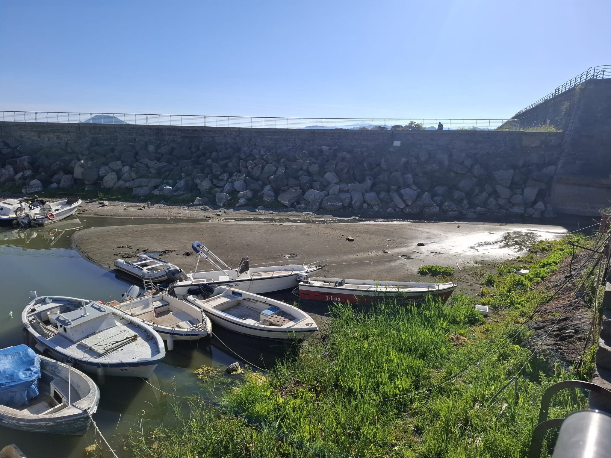 La Darsena di Pozzuoli prosciugata: montagna di sabbia impedisce l’uscita delle barche – LE FOTO