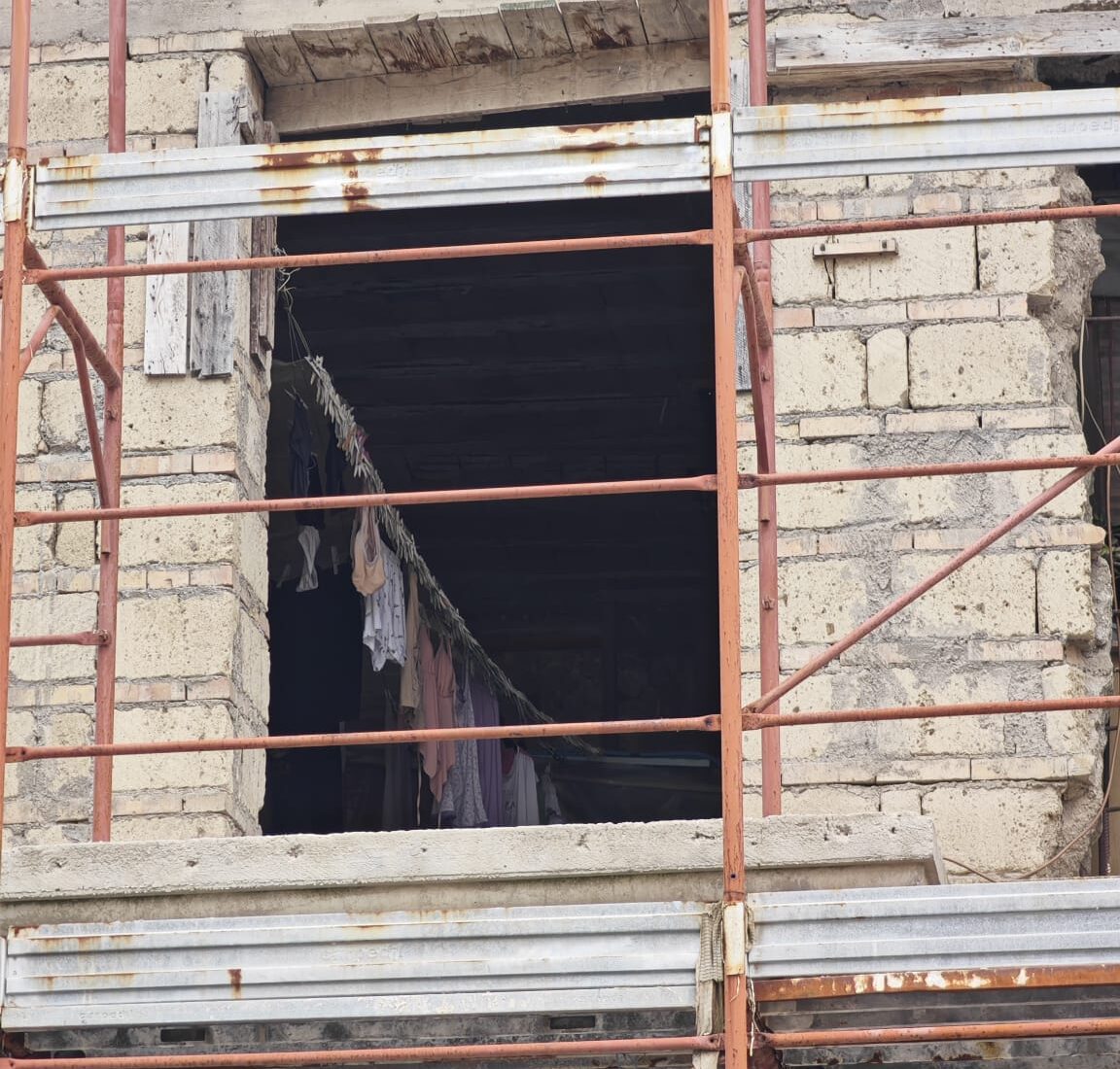 Panni stesi, una pianta tra le crepe e una donna: a Pozzuoli c’è chi vive in un palazzo pericolante